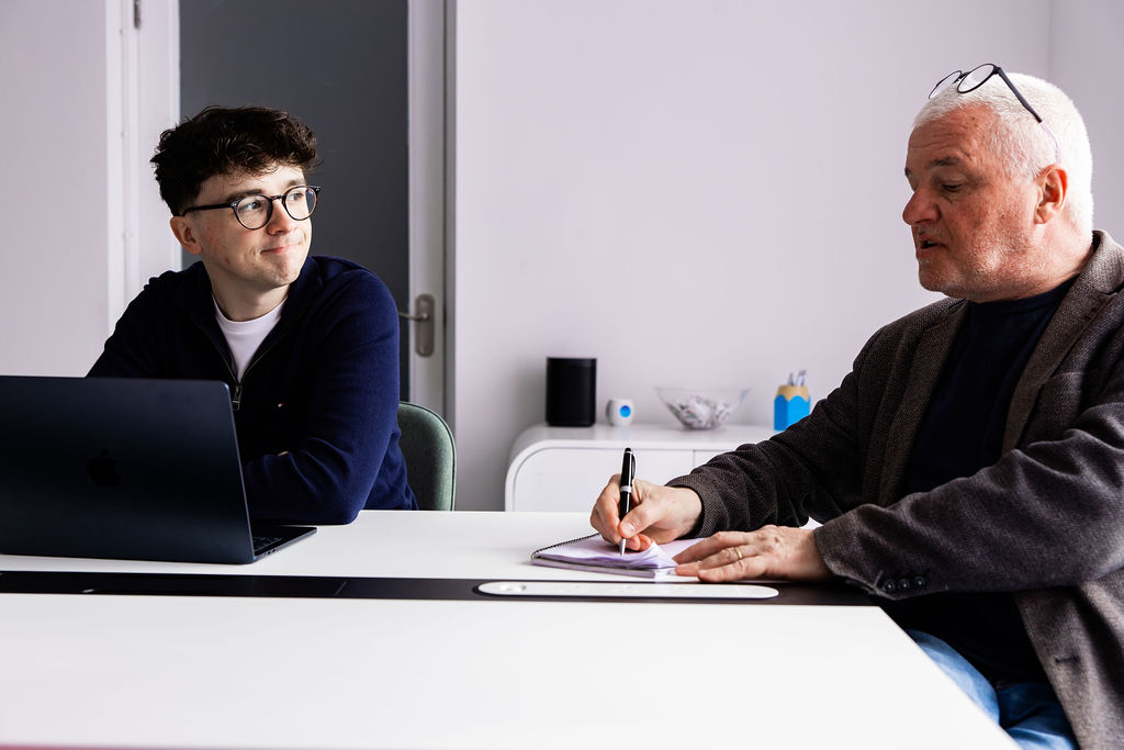 Two Schudio colleagues in a meeting, one taking notes